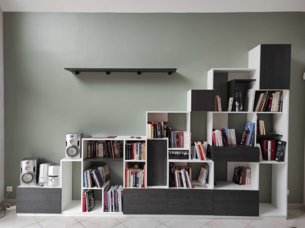 Bibliothèque réalisée sur mesure en noir et blanc mise en valeur par le pan de mur vert kaki clair - Concept Déco LV - Décoratrice d'intérieur à Caen