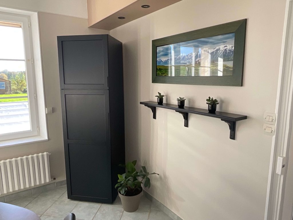 Petit étagère noire avec un beau cadre photo accroché au mur qui apporte une pointe de déco élégante - Concept Déco LV- Décoratrice d'intérieur à Caen
